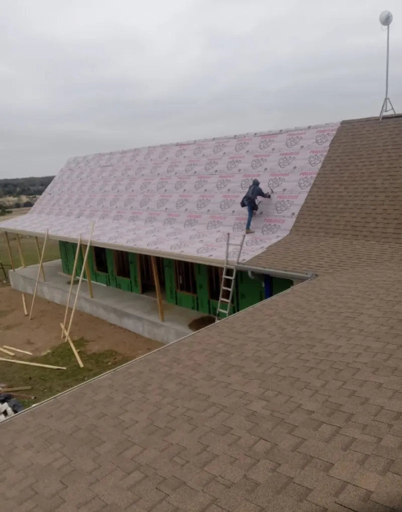 Worker preparing underlayment for a metal roof installation in North Lynnwood